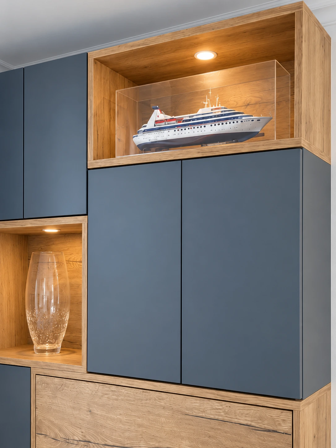 Détail des niches en décor bois éclairées, maquette de bateau et vase en verre