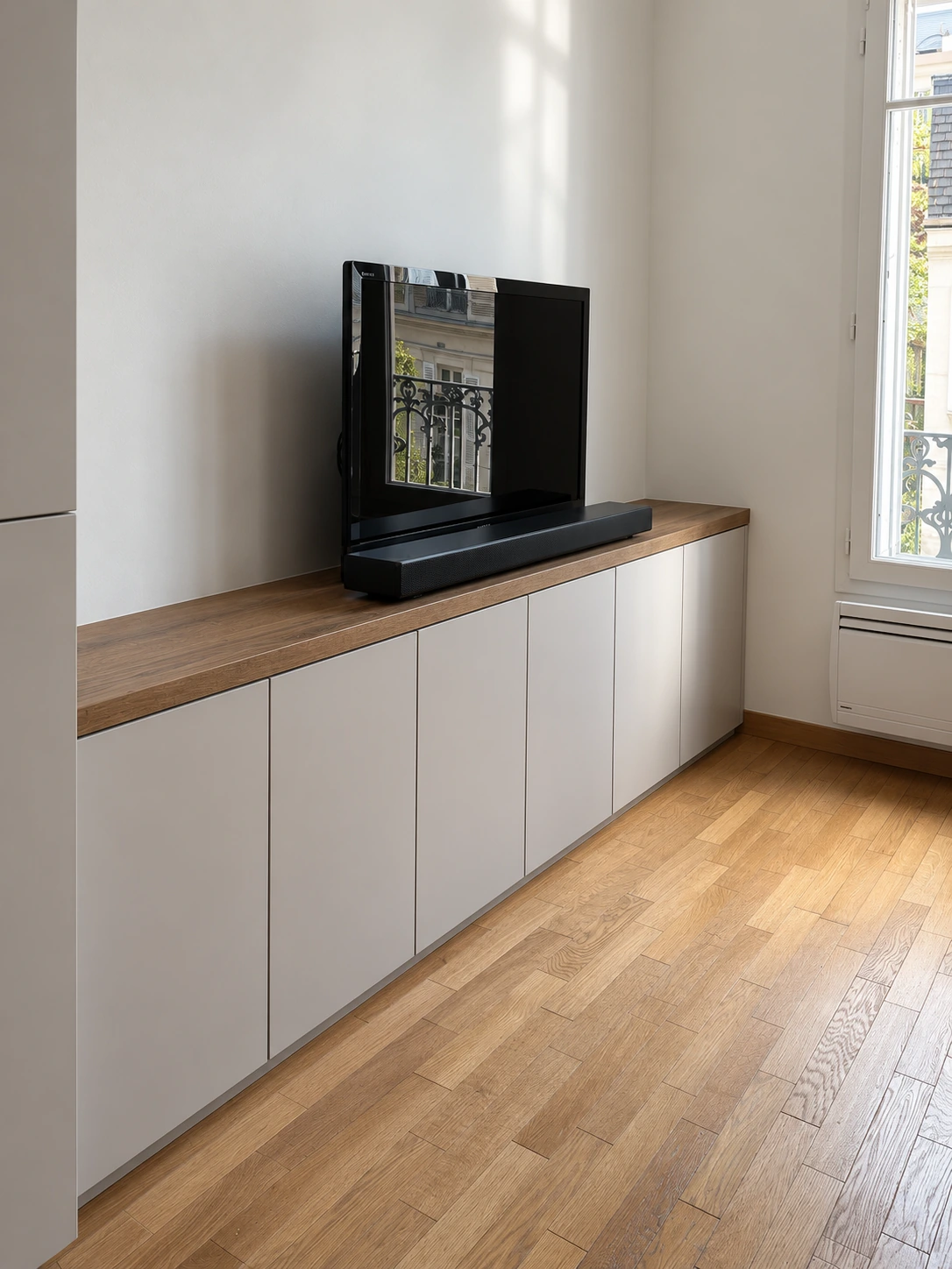 Meuble TV bas à six portes, plateau en bois et télévision posée