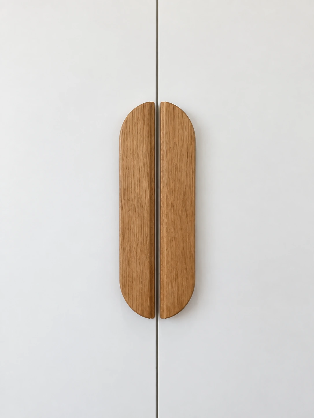 Poignées allongées en bois sur les façades blanches des rangements