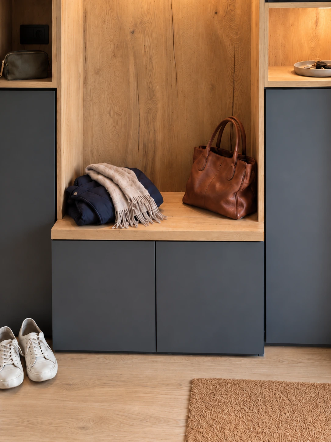 Banquette en décor bois avec rangements fermés, sac et vêtements du quotidien