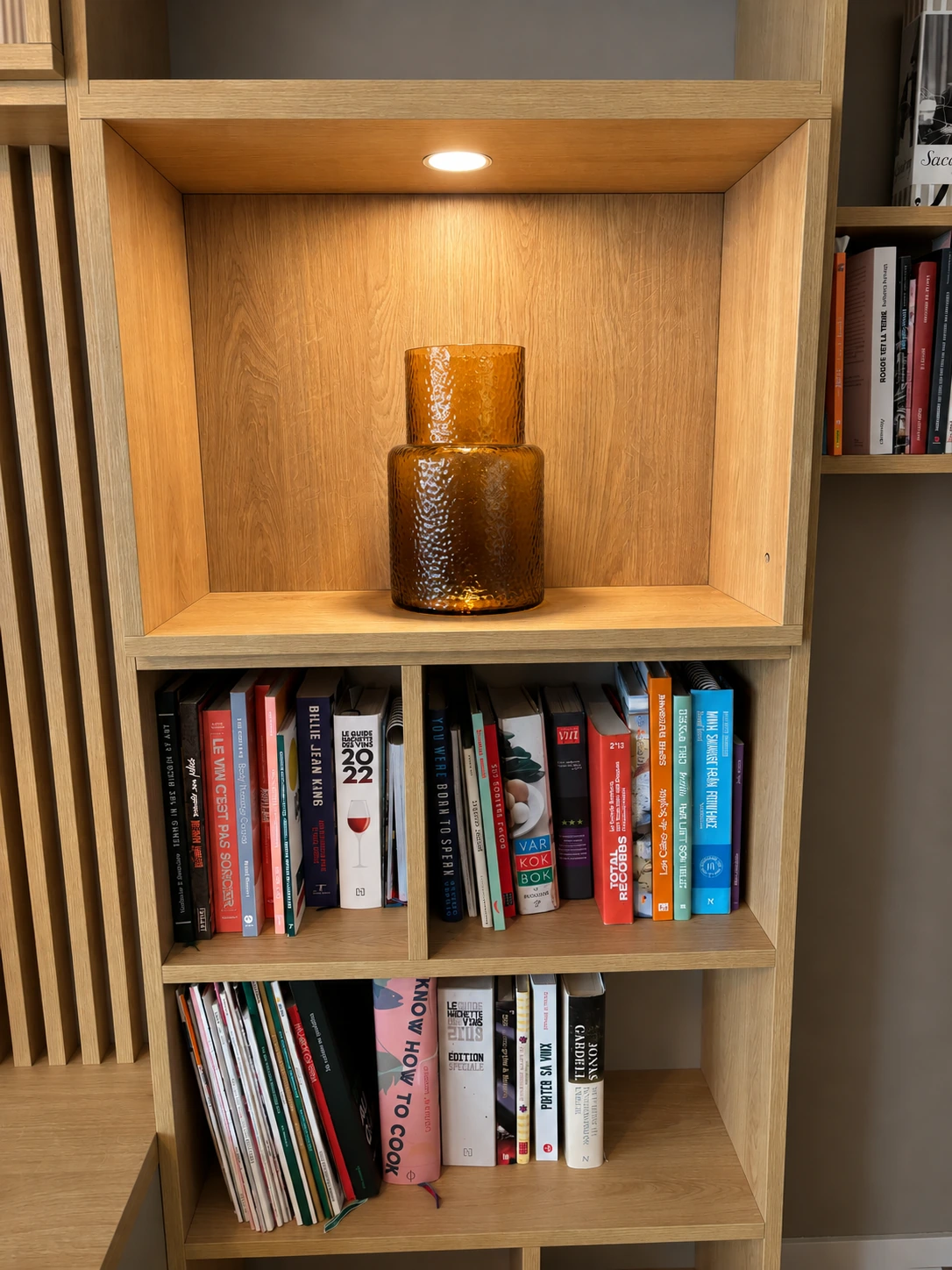 Niche éclairée en décor bois et étagères de livres