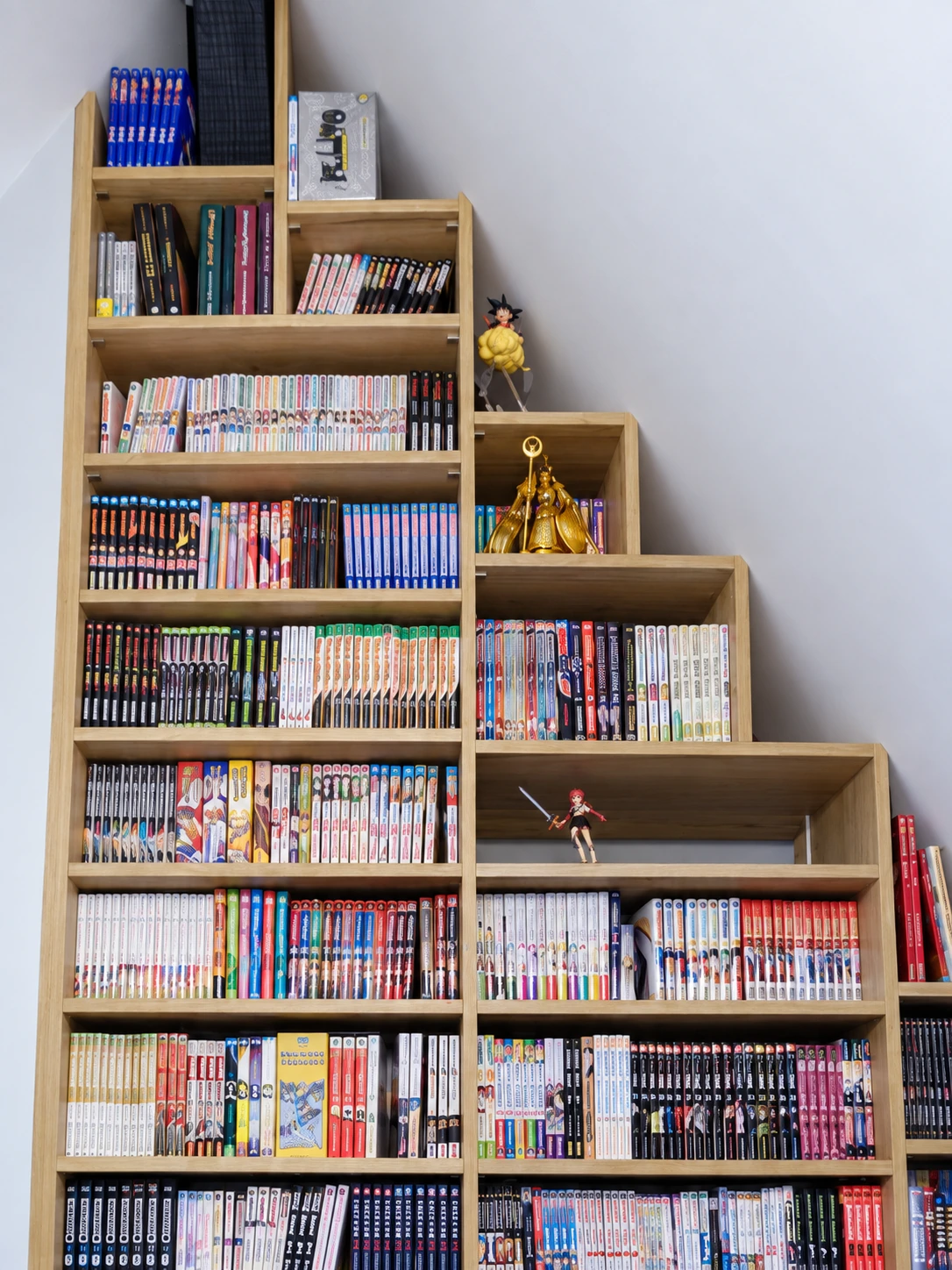 Détail des étagères sous pente remplies de mangas et de figurines